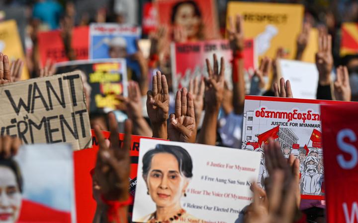 Protesters hold up the three finger salute with signs calling for the release of detained Myanmar civilian leader Aung San Suu Kyi during a demonstration against the military coup in Yangon on 16 February, 2021.