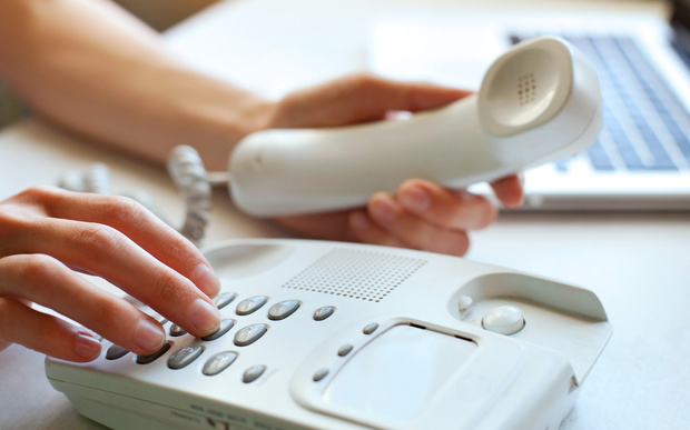 A person dials a number on a home landline phone (file)