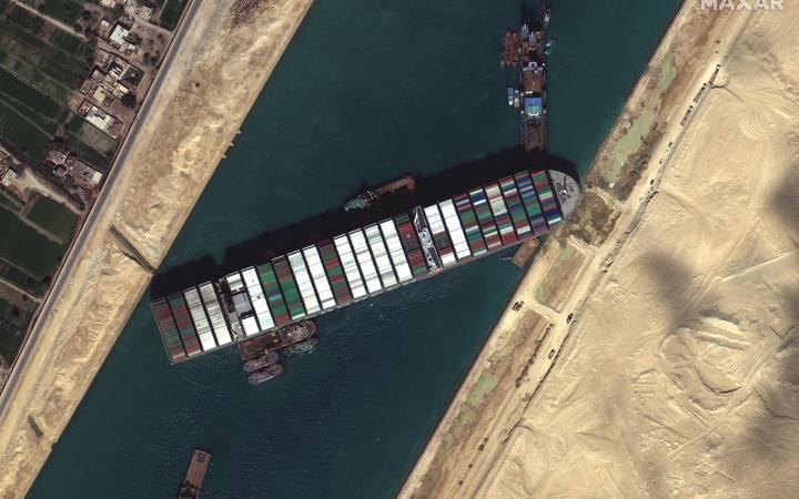 Tug boats and dredgers on March 27, 2021, attempting to free the ship Ever Given, which was lodged sideways and impeding all traffic across Egypt's Suez Canal. 