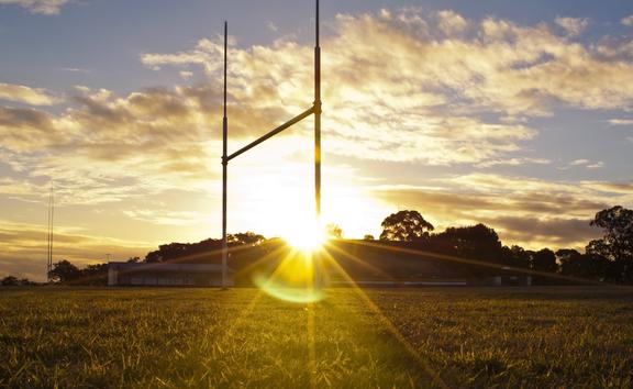 14437716 - goal posts for football, rugby union or league on field at sunset
