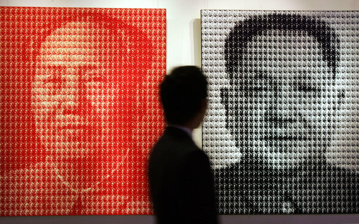 A prospective buyer views two paintings by South Korean artist Kim Dong Yoo entittled "Mao Zedong (L) and Deng Xiaoping (R)" prior to it going under the hammer at Christie's Spring sale, in Hong Kong 27 May 2007. 