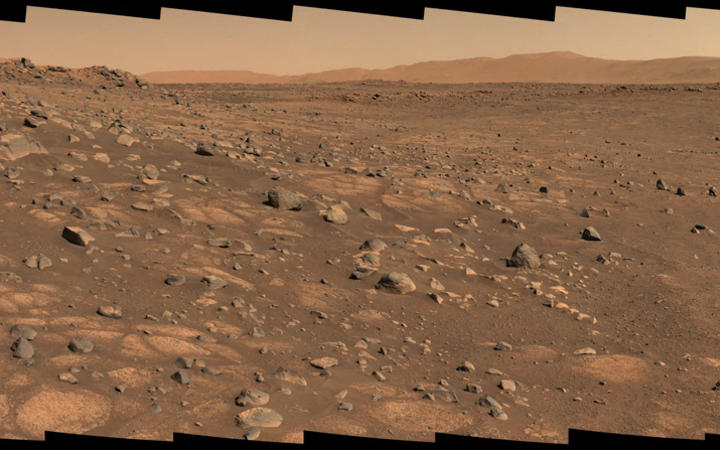This Nasa photo taken 8 July 2021, shows the 'Cratered Floor Fractured Rough' geologic unit at Jezero Crater. A light-colored, paver stone, like the ones seen in this mosaic image, will be the likely target for first sampling by the Perseverance rover.