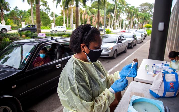 A health worker prepares a dose of the AstraZeneca vaccine for a resident at a drive-through vaccination centre in Suva.