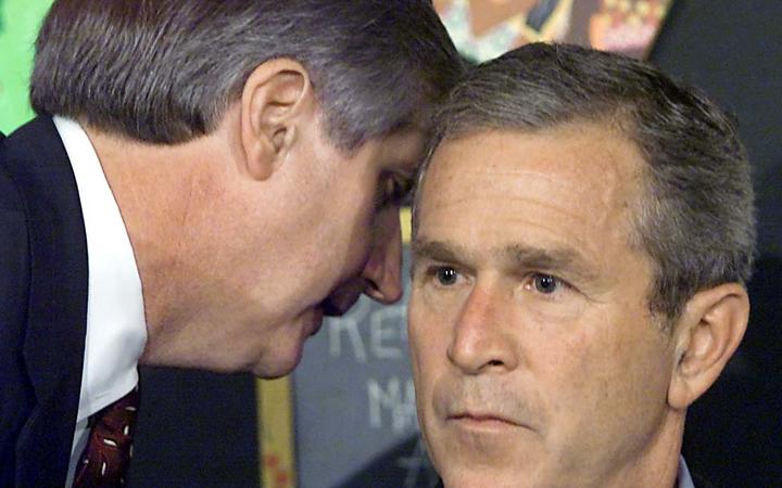 White House Chief of Staff Andy Card tells US President George W. Bush about the terror attack on the World Trade Center, while Bush is reading to children at a school visit.