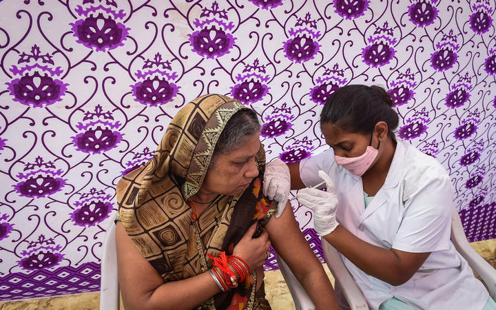 A health worker inoculates a woman with the jab of Covishield Covid-19 coronavirus vaccine at a temporary vaccination camp in Ahmedabad, India.