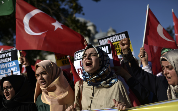 Pro-Erdogan protesters wave Turkish flags and shout slogans as they demonstrate in Istanbul in support the government on July 16, 2016, following a failed coup attempt.