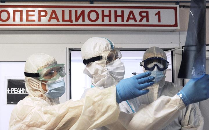 Medics wearing personal protective equipment (PPE) view an X-ray of the lungs at the intensive therapy department of a hospital for people suffering from the coronavirus disease, in Rasskazovo, Tambov region, Russia.