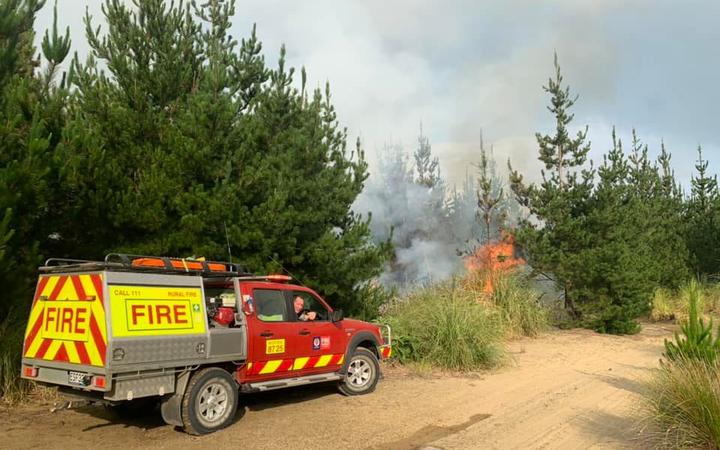 The Muriwai Volunteer Fire Brigade tackling a forest fire which started from a campfire at Muriwai Beach.