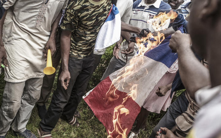 Des manifestants brûlent un drapeau français à Bamako lors d'une manifestation contre l'influence française dans le pays.