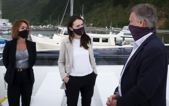 Prime Minister Jacinda Ardern (centre) viewing the electric ferry at Wellington Harbour with East By West managing director Jeremy Ward (right).