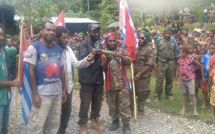 A West Papuan community from Pegunungan Bintang regency displays an apparent unexploded bomb found in its village following aerial attack, October 2021.
