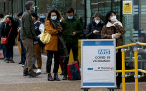 People queue to receive coronavirus vaccines in front of the St. Thomas Hospital due to the increase in cases of the Omicron variant of the COVID-19 in London, United Kingdom