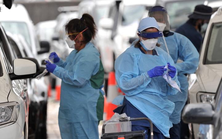 Health workers conduct PCR tests at the St Vincent's Bondi Beach COVID-19 drive through testing clinic on December 22, 2021 in Sydney, as the number of COVID-19 cases keeps on the rise 