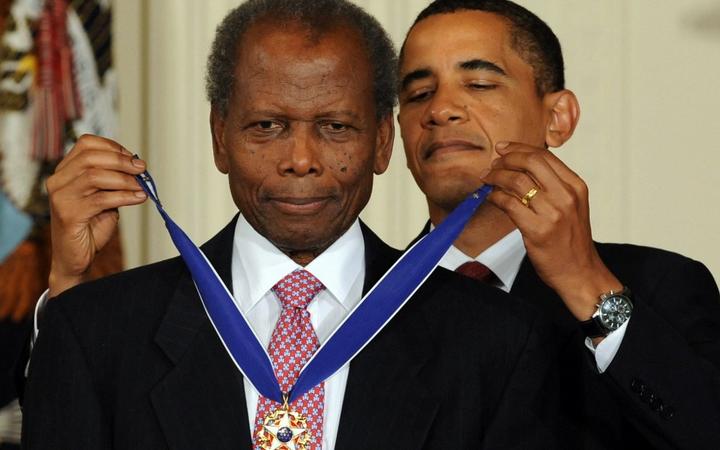 (FILES) In this file photo taken on August 12, 2009, US President Barack Obama presents the Presidential Medal of Freedom to ambassador and actor Sidney Poitier during a ceremony in the East Room at the White House in Washington, DC. 
