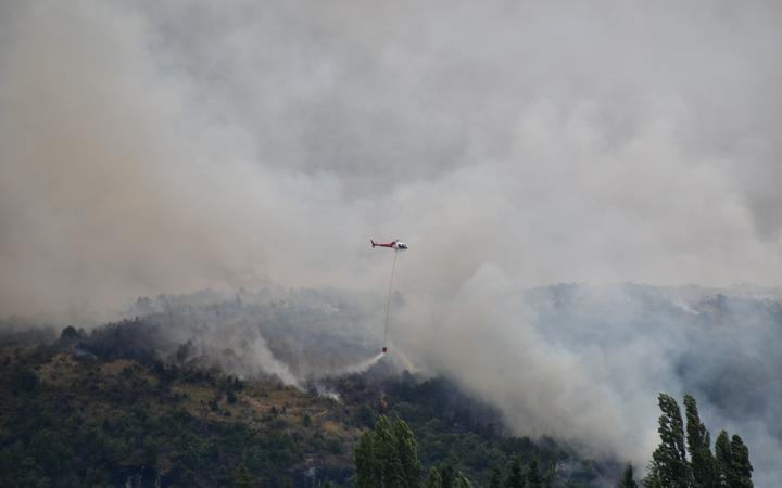 Helicopters with monsoon buckets continue to battle the fire.