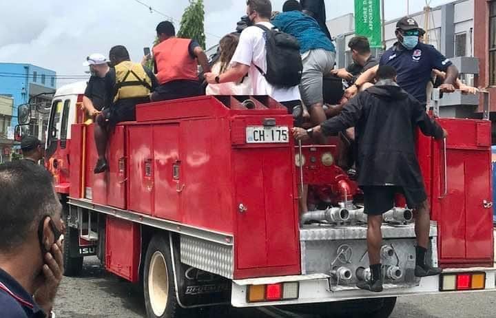 Fijian firefighters give tourists a ride to Nadi Airport amid Cyclone Cody.