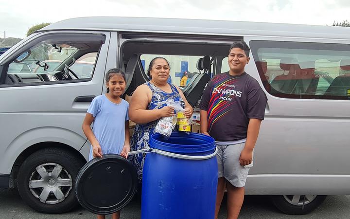 This family is packing needed supplies for family on Tongatapu
