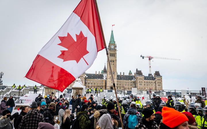 Demonstrators continue their protest in front of Parliament Hill in Ottawa as police deploy to remove them.