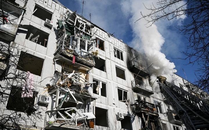 Firefighters work on a fire on a building after bombings on the eastern Ukraine town of Chuguiv on February 24, 2022.