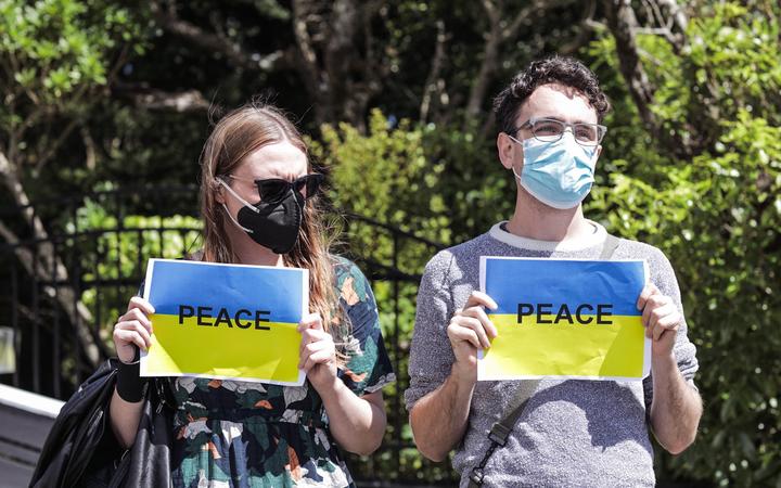 Protesters holding peace signs in the colours of the Ukrainian flag