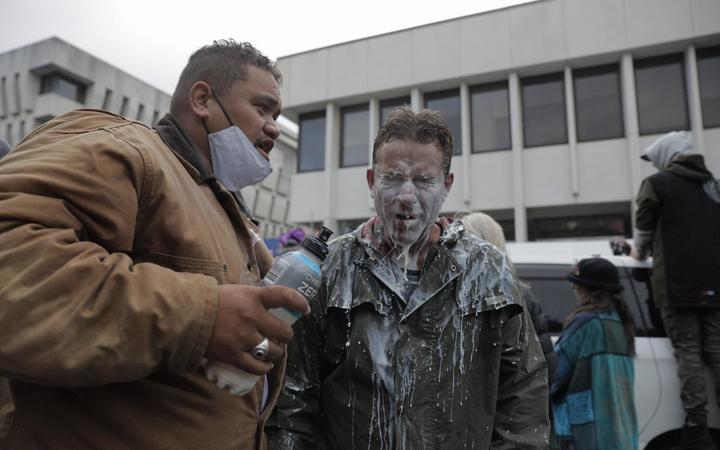 A protester seen with milk on their face - something used to cool the effects of pepper spray.