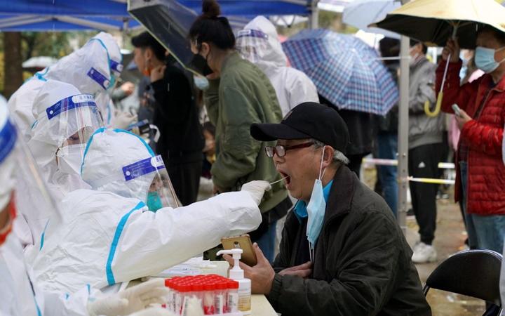 Citizens receive nucleic acid tests at a residential area in east China's Shanghai, March 17, 2022.