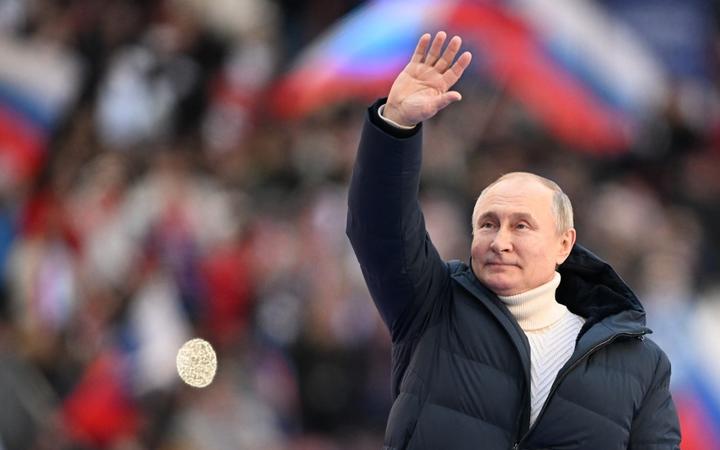 8143885 18.03.2022 Russian President Vladimir Putin waves during a concert marking the 8th anniversary of the referendum on the state status of Crimea and Sevastopol and its reunification with Russia, at Luzhniki Stadium in Moscow, Russia. 