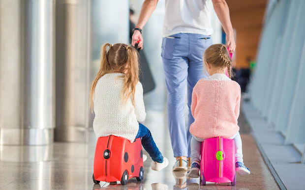 Children at airport with suitcases