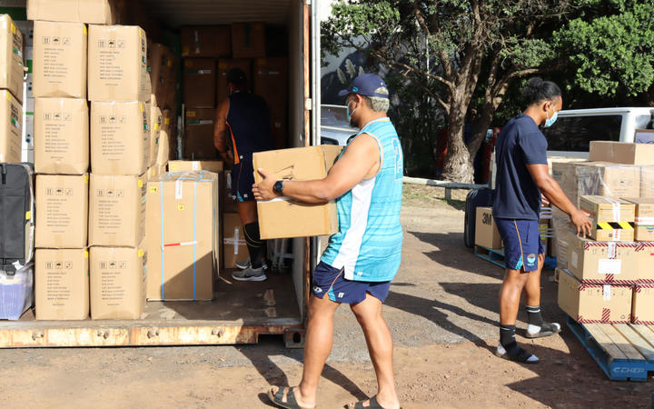 Moana Pasifika players Isi Tu'ungafasi and Don Lolo Penitau Finau loading up the containers of supplies for Tonga