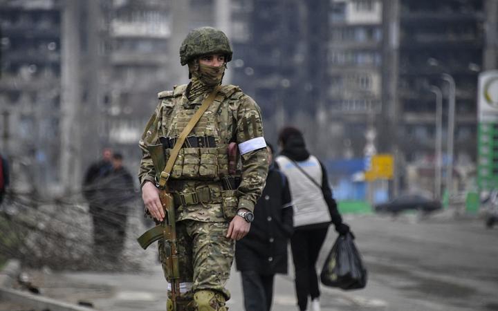 A Russian soldier patrols in a street of Mariupol on April 12, 2022, as Russian troops intensify a campaign to take the strategic port city, part of an anticipated massive onslaught across eastern Ukraine, while Russia's President makes a defiant case for the war on Russia's neighbour. 