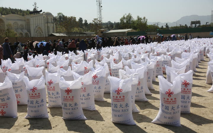 People wait to receive food aid from China in Kabul, Afghanistan, on April 7, 2022. 
