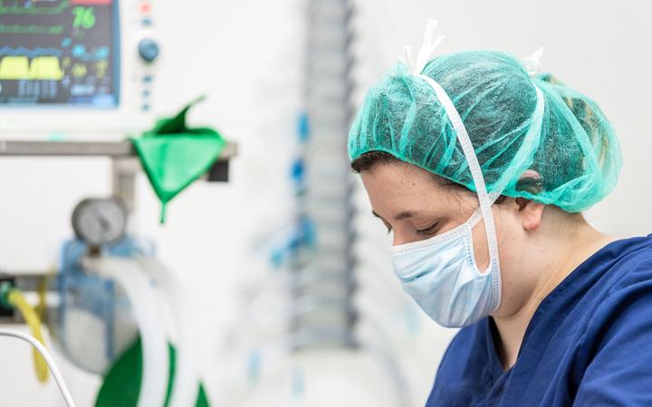 Covid-19 outbreak. Healthcare worker. Nurse working in intensive care unit. Mechanical ventilation system in the background .