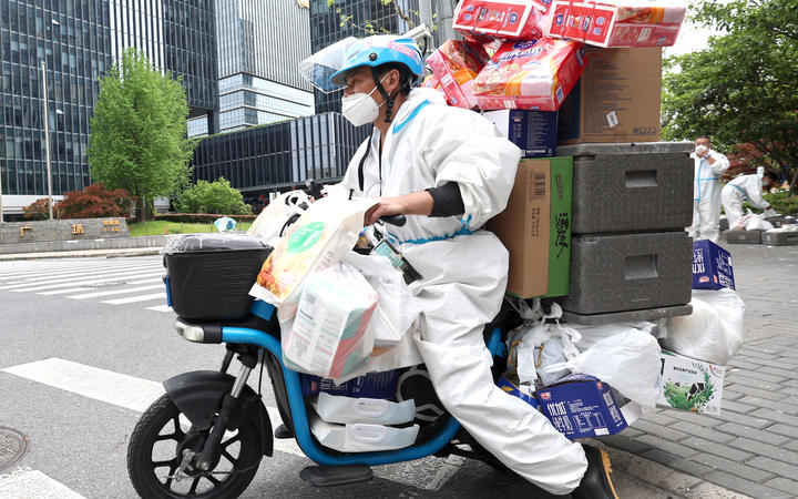 A delivery man from Jiangxi Province delivers goods in Shanghai, east China, April 15, 2022. 