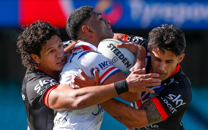 Dallin Watene-Zelezniak and Jesse Arthars tackle Daniel Tupou during the Sydney Roosters match against the Vodafone Warriors in Sydney. 