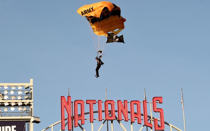 WASHINGTON, DC - APRIL 20: A member of the US Army Parachute Team The Golden Knights lands at Nationals Park before the game between the Washington Nationals and the Arizona Diamondbacks on April 20, 2022 in Washington, DC.  