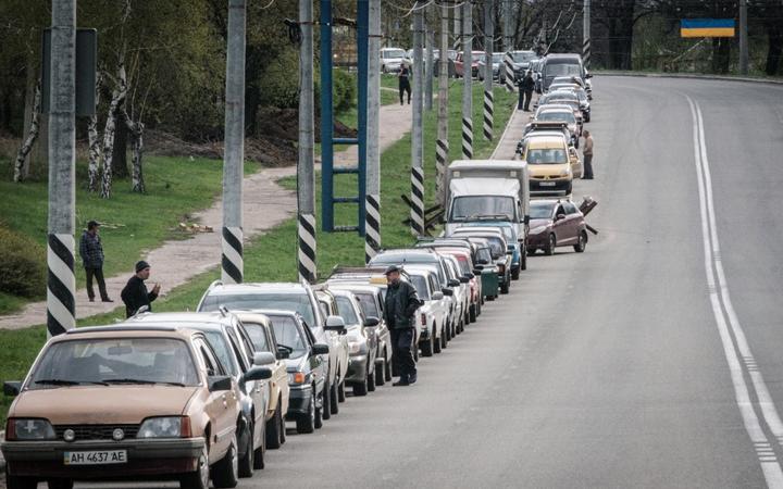 Local residents wait in line with their car to fill up with liquefied natural gas near a petrol station in Kramatorsk, eastern Ukraine, on April 21, 2022. 