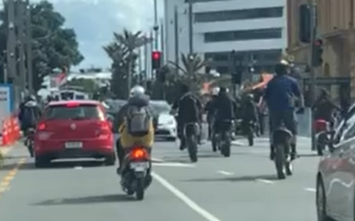 Screengrab of a group of 30 bikers driving through red lights in Auckland