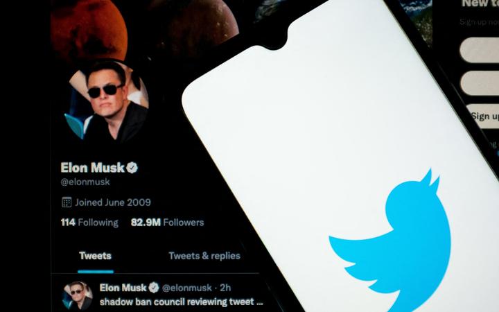 In this photo illustration Twitter logo seen displayed on a smartphone screen with Elon Musk Twitter in the background in Chania, Crete Island, Greece on April 23, 2022. )