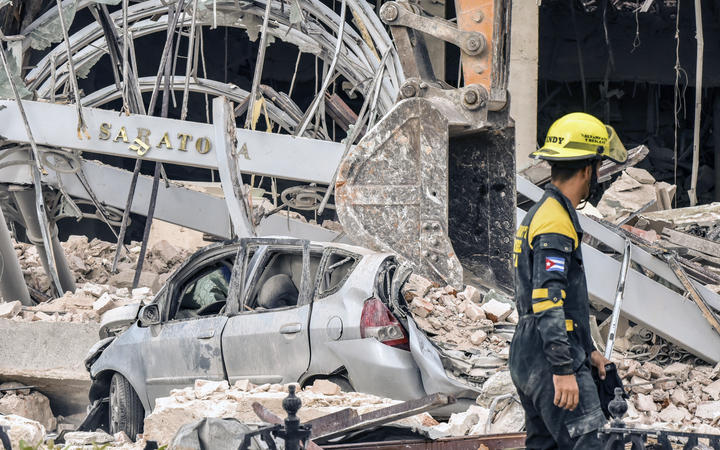 A rescuer helps after a huge blast wrecked the Saratoga Hotel in Havana on 6 May 2022.