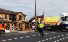 Fire crews remove the truck from a Papatoetoe home.