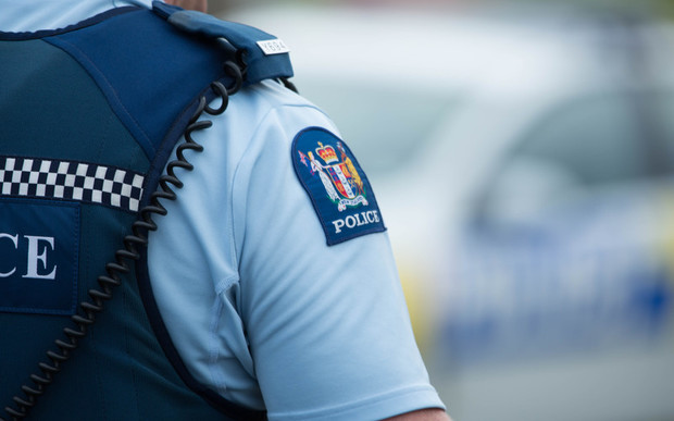 Close up of a police officer at an incident on a residential street. 6 July 2016.