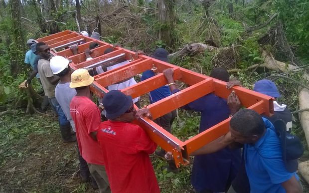 Villagers with the portable sawmill being used to mill timber for the post cyclone rebuild on Koro, Fiji