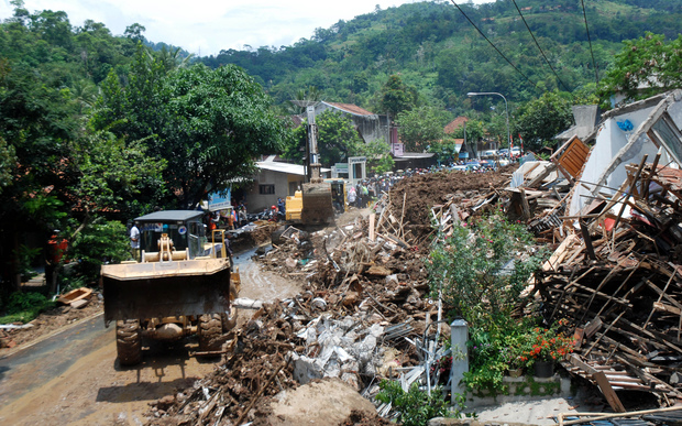An Indonesian search and rescue team joined by volunteers remove debris from an area hit by a landslide in Sumedang on 21 September. 