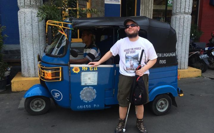 Tony Giles in Jakarta standing in front of a bajaj
