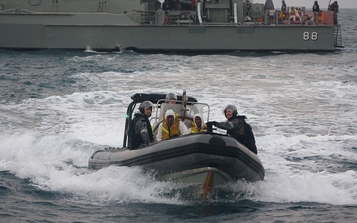 Australian navy personnel transfer Afghanistan asylum-seekers to a Indonesian rescue boat near Panaitan island, West Java on August 31, 2012 after the refugee's boat sunk. 