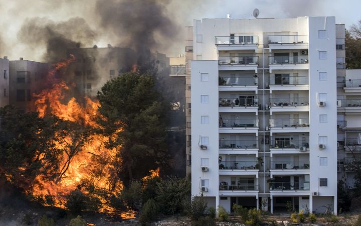 A fire rages next to an apartment building in Haifa.