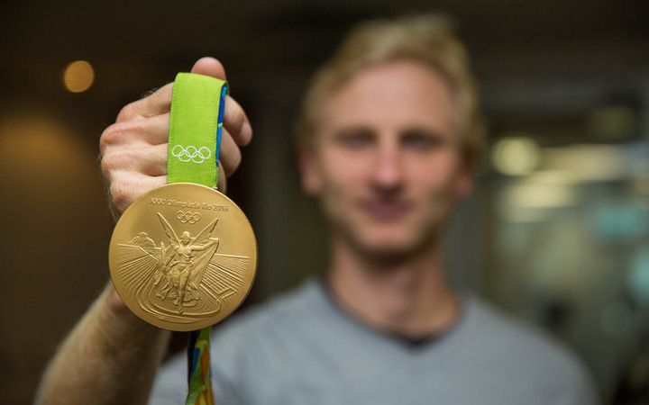 Hamish Bond holding his Olympic gold medal from the Rio 2016 Olympics