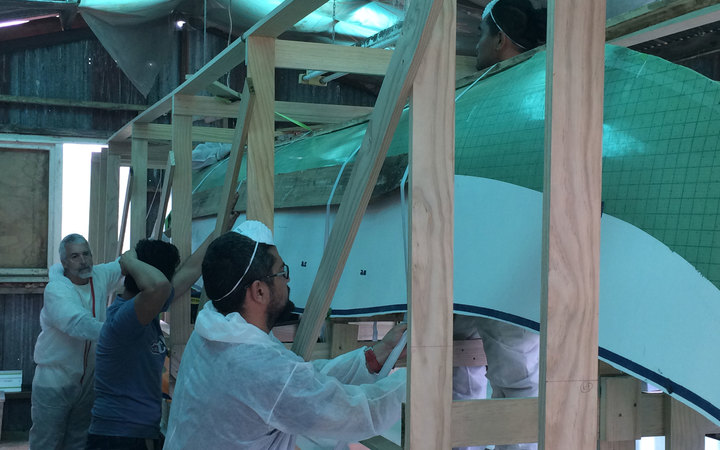 The team works on the canoe.