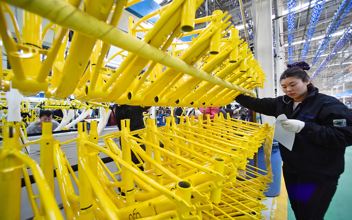 A worker prepares parts for bicycles of Chinese bike sharing service Ofo at a factory in Tianjin, China, 16 March 2017