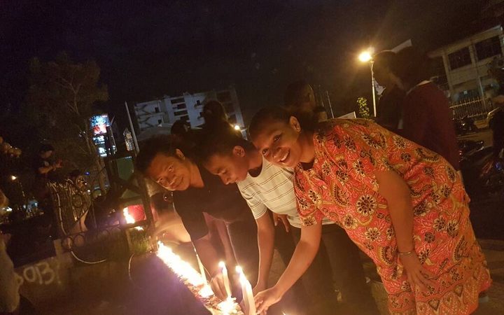 People in Jayapura light candles to show support for the jailed former governor of Jakarta, Ahok.